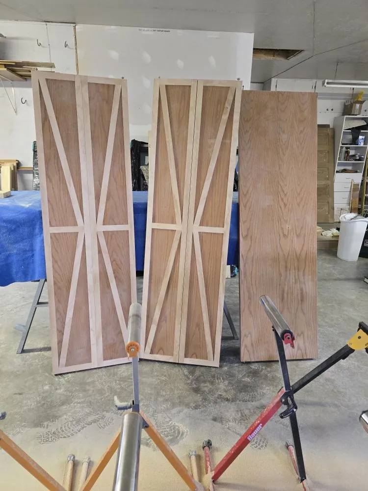Custom bifold doors in the shop — oak with modern X-brace trim accents.
