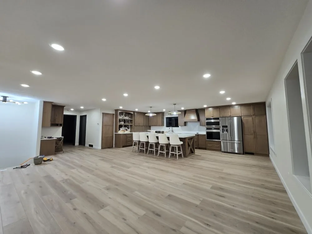 Open-concept kitchen with custom maple cabinets, large island, stone countertops, and breakfast nook — the Tappen Project.